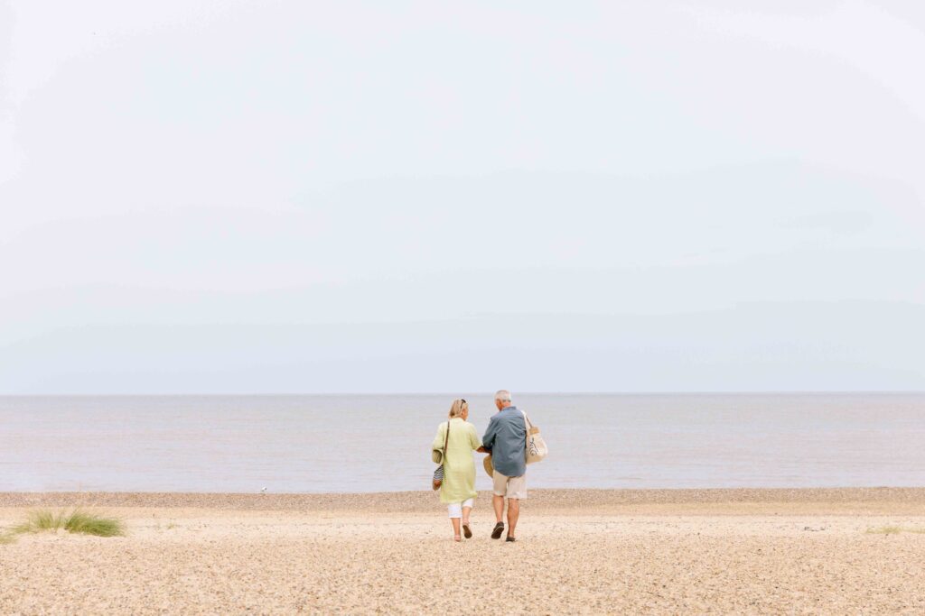 Two people walking on the beach.