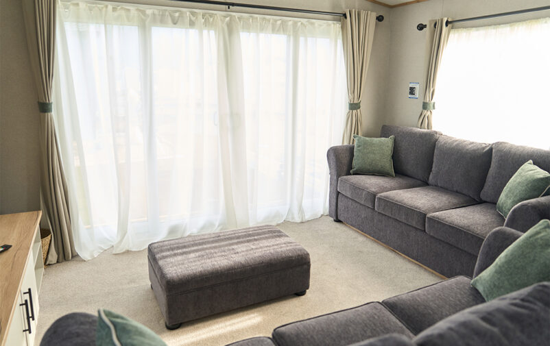 Bright living room with large windows and comfortable sofas.