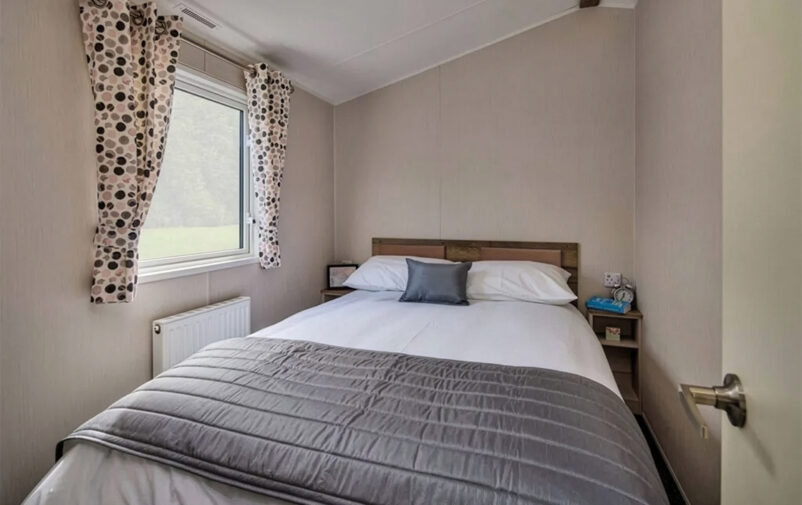 Comfortable bedroom with double bed and window at Lovat Parks.