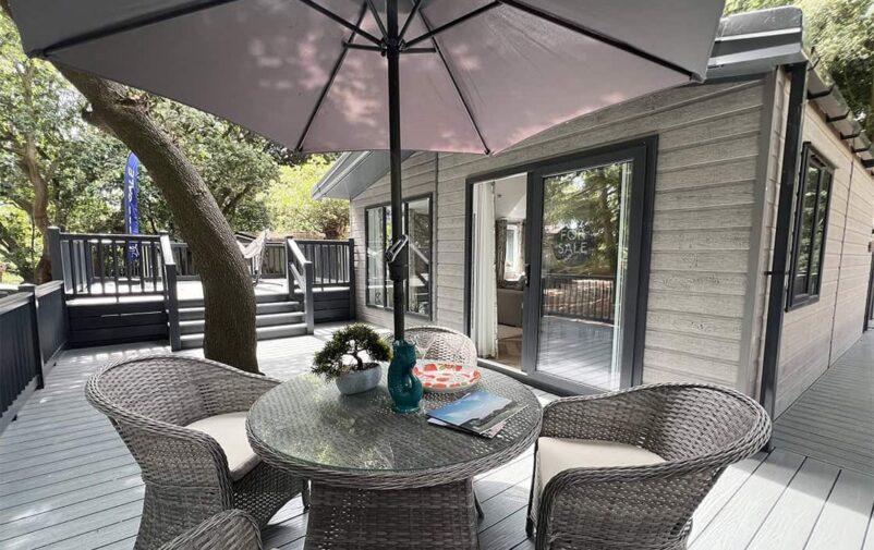 Outdoor patio at Victory Wisteria Lodge with table, chairs, and umbrella.
