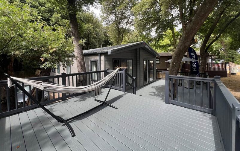 Spacious outdoor deck at Victory Wisteria Lodge with hammock and trees.