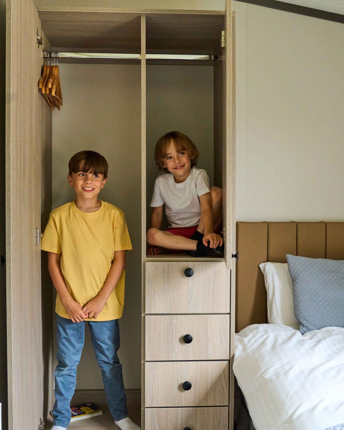 Two little brothers in a cupboard.