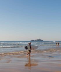 Man on the beach with a surf board.