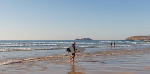 Man on the beach with a surf board.