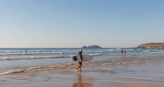 Man on the beach with a surf board.