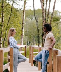 A couple standing on a bridge.