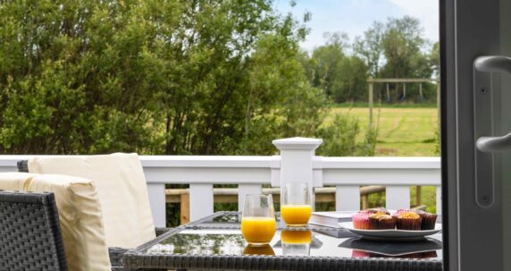 View on the deck of a lodge with a spread of juice and food out.