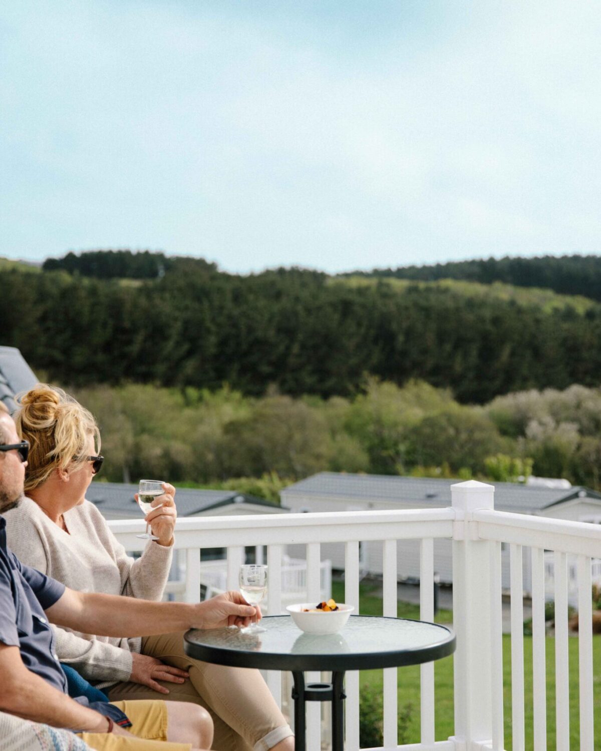 A couple sitting on the decking a lodge.