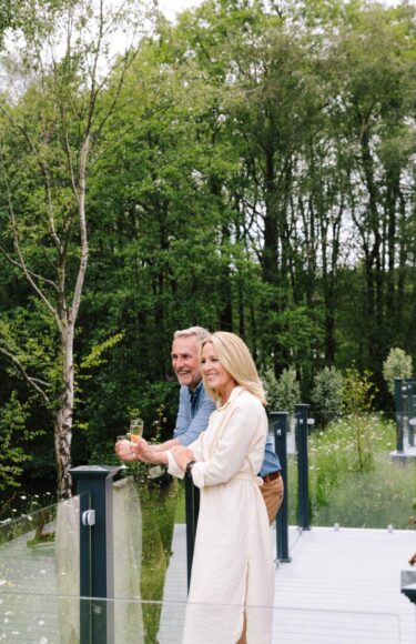 Couple standing on decking.