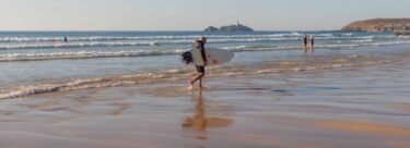 Man on the beach with a surf board.