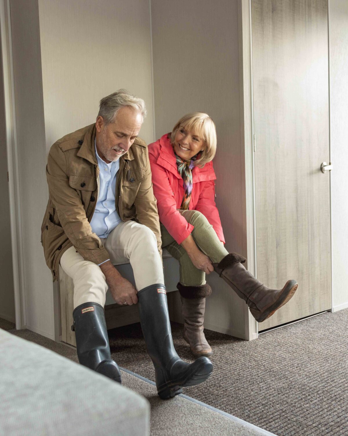 Two people putting their boots on.