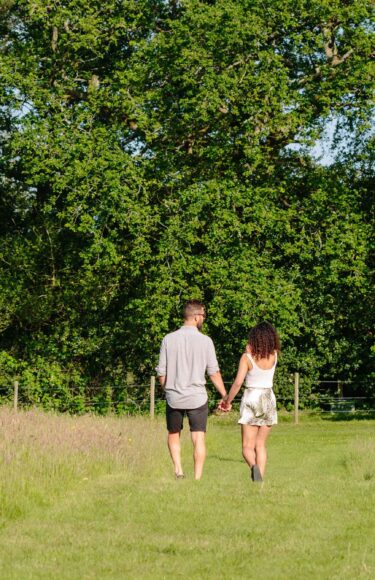 Couple walking in a field.