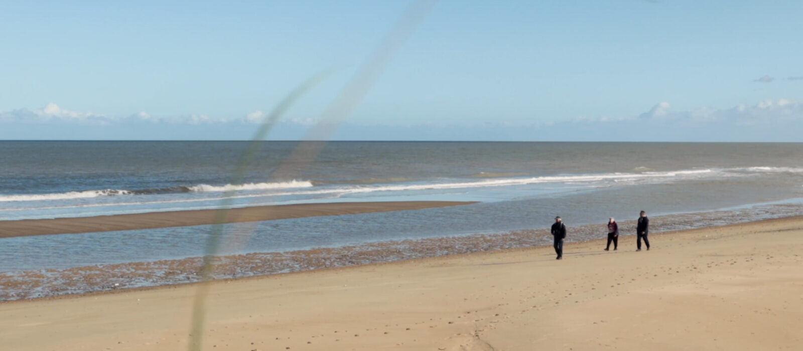 A couple walking down a beach.